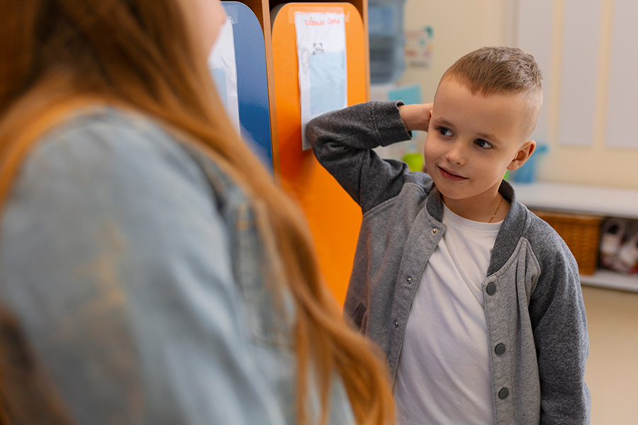 Young student interacting with an educator in a classroom.